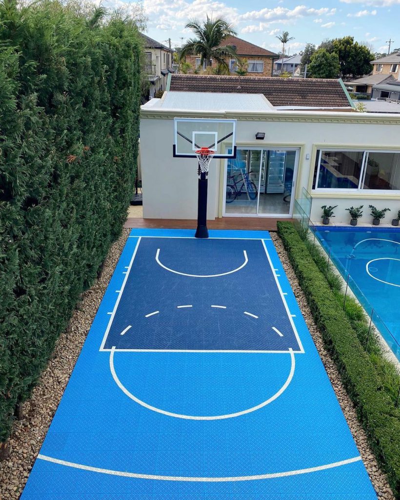 A finished backyard basketball half-court built with Outdoor Sport Courts interlocking tiles